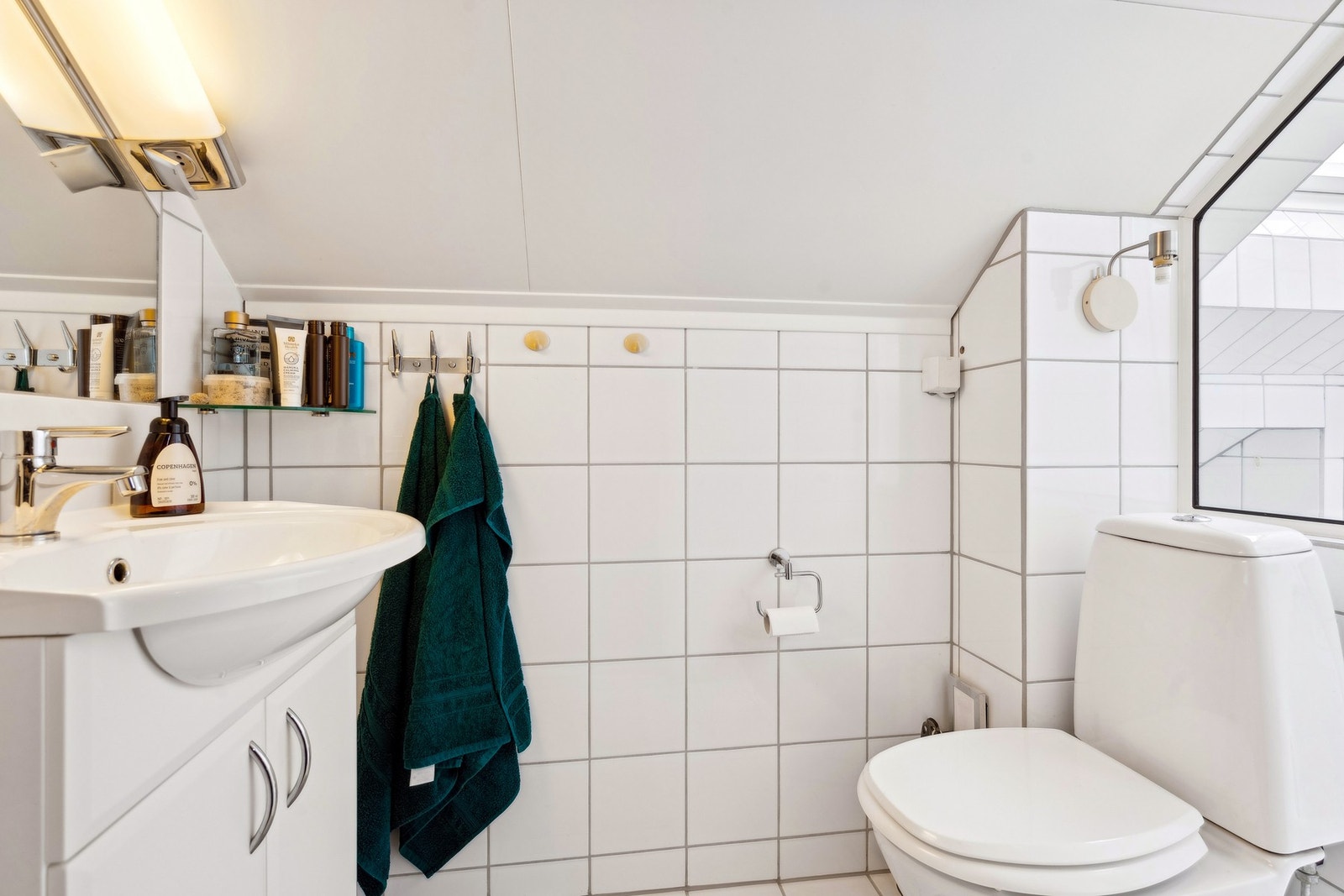 Bad 1 har innredning med nedfelt servant, toalett, dusjvegger/hjørne og opplegg for vaskemaskin. Galleribilde