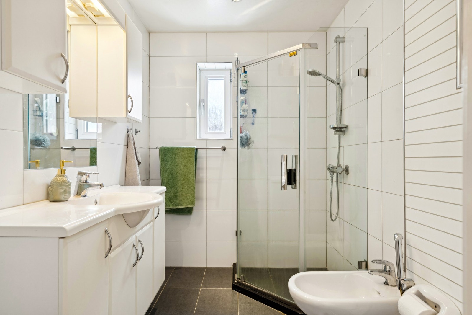 Badet har innredning med nedfelt servant, veggmontert toalett og dusjvegger/hjørne. Bidet er montert. Galleribilde