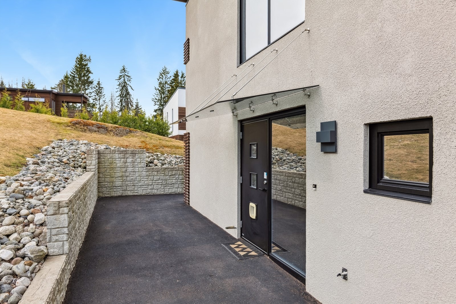 Koselig inngangsparti som er overbygget med tak med tilhørende skjermet uteområde som byr på god plass til utemøblement. Galleribilde