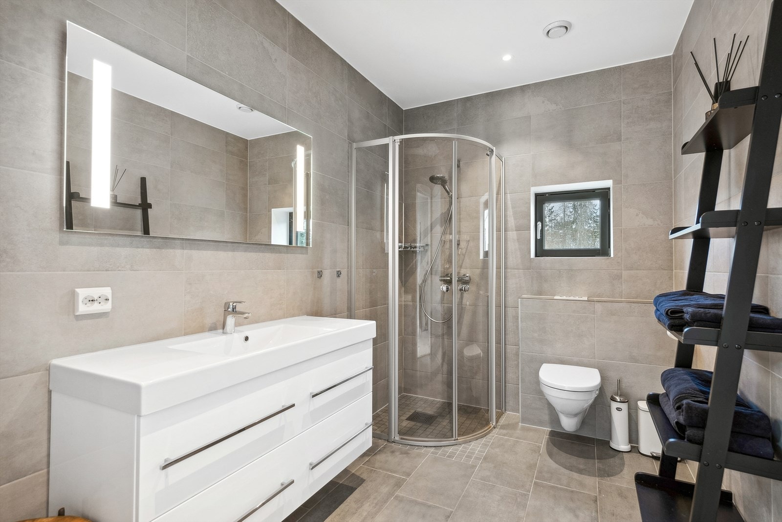 Baderommet i boligens 2. etasje er gjennomført med flotte fliser i moderne og lyse fargetoner på vegger og gulv. Det er i tillegg behagelige varmekabler i gulvet. Galleribilde