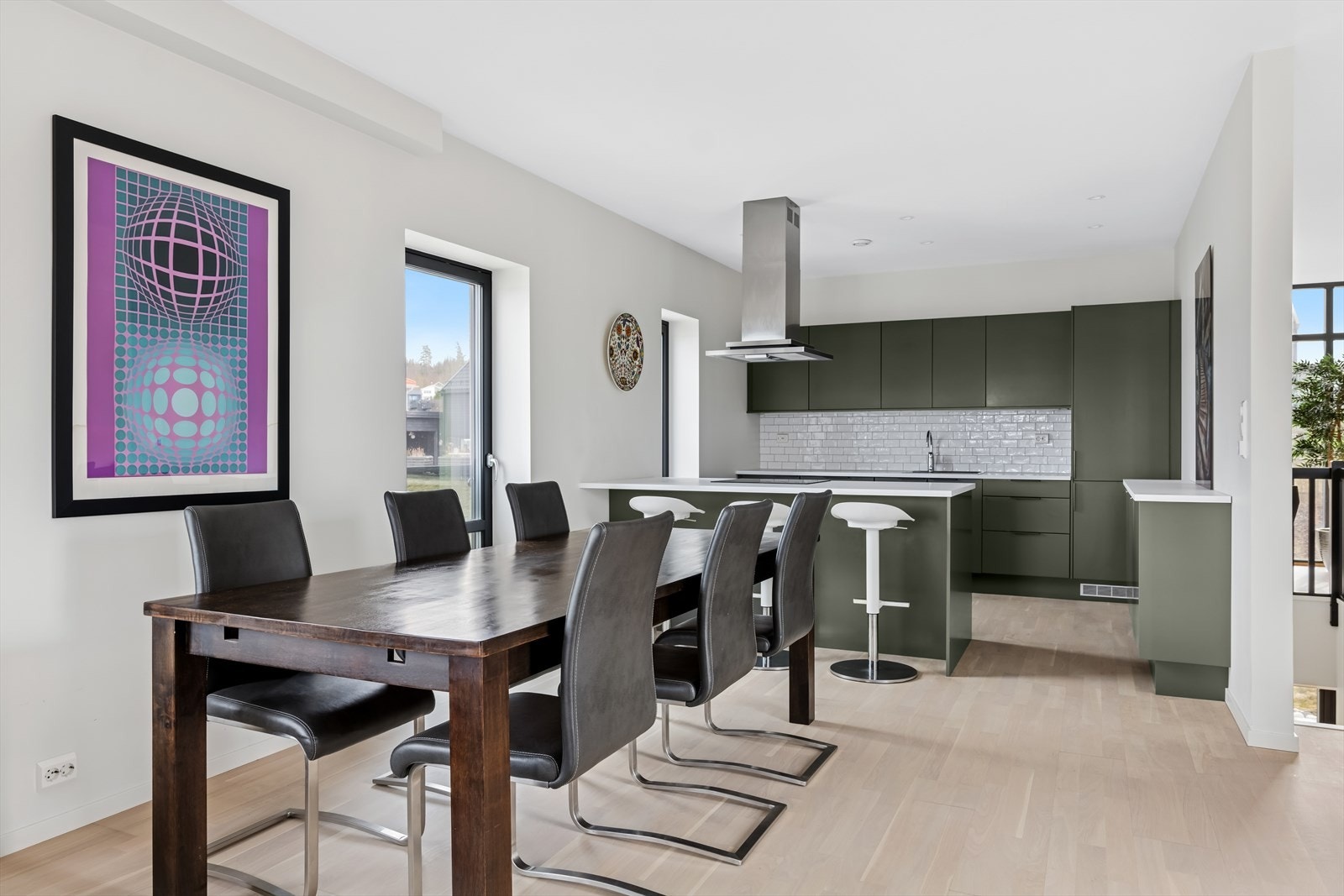 Det flotte kjøkkenet har åpen løsning mot stuen med en moderne, stilfull og påkostet kjøkkeninnredning fra Sigdal i grå utførelse. Det er god plass til stort spisebord i sonen mellom kjøkken og stue. Galleribilde