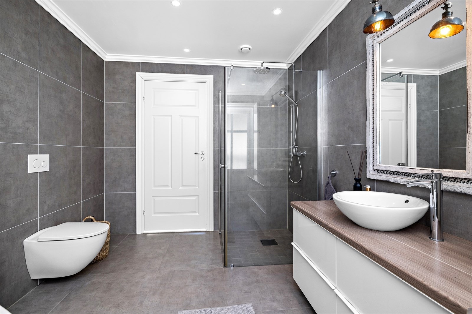 Moderne innredet hovedbad i 2.etasje som ligger praktisk i tilknytning til soverommene med 60X60 fliser og mosaikkfliser i dusjsone. Galleribilde
