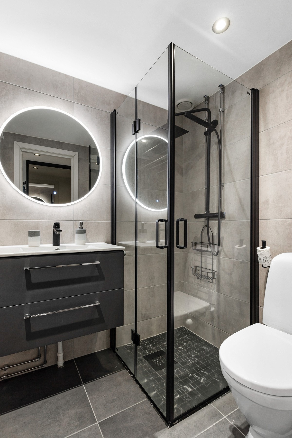 Videre er det montert et vegghengt servantskap med heldekkende servant og ett-greps blandebatteri, samt et speil med lys Galleribilde