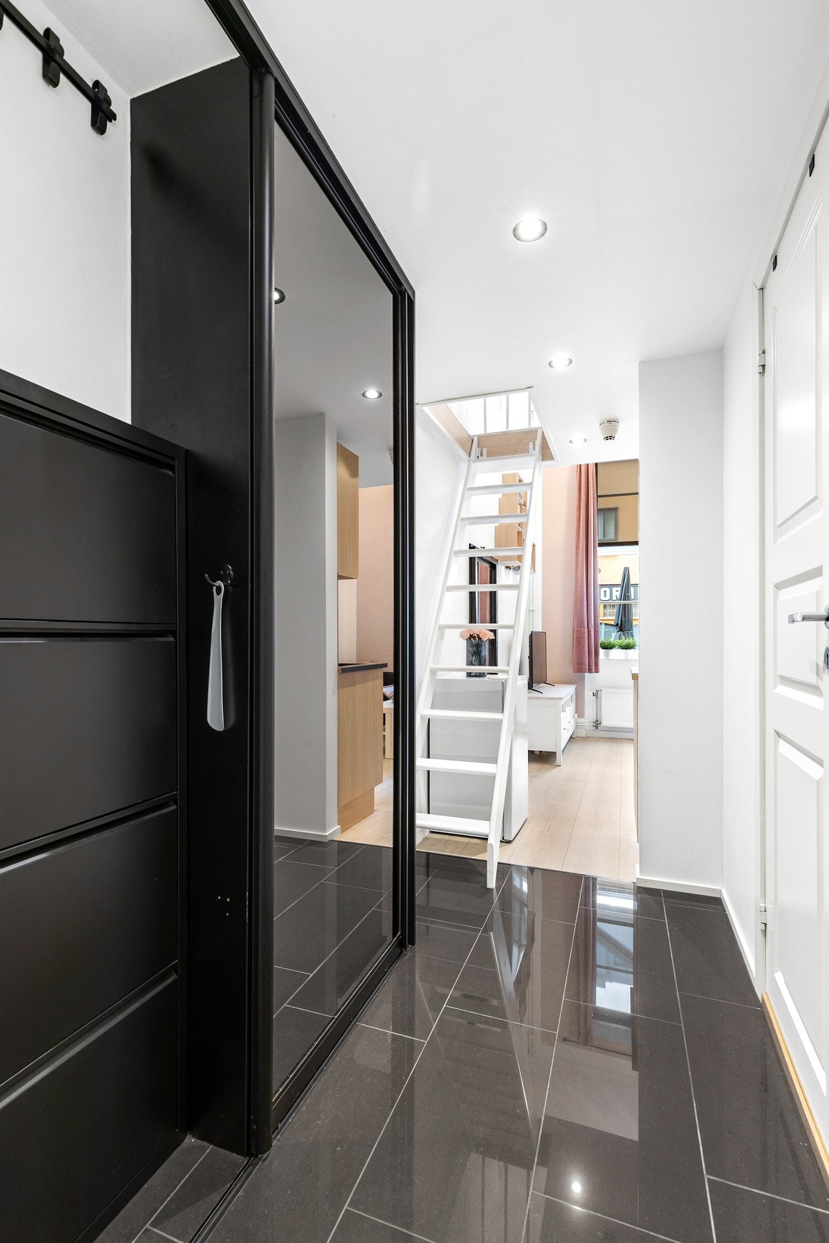 Det er montert praktisk skyvedørsgarderobe med speilfronter for oppbevaring av yttertøy og sko Galleribilde