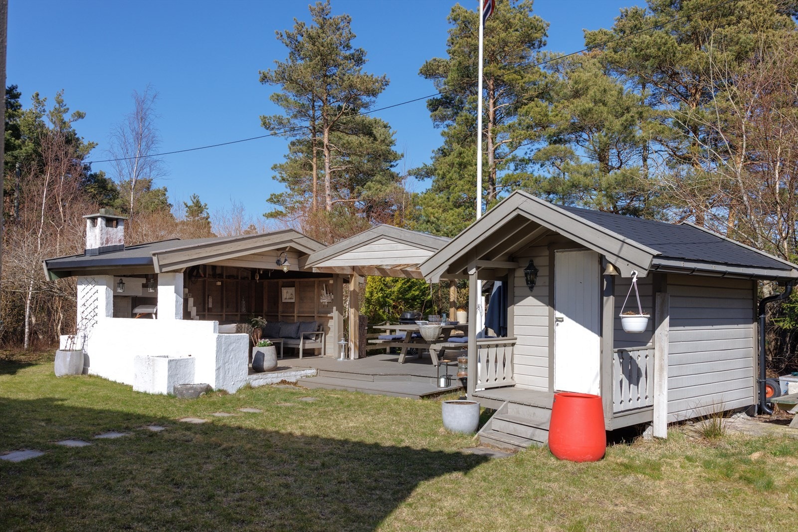 På østsiden ligger en overbygd spiseplass med oppmurt peis og utekjøkken. Galleribilde