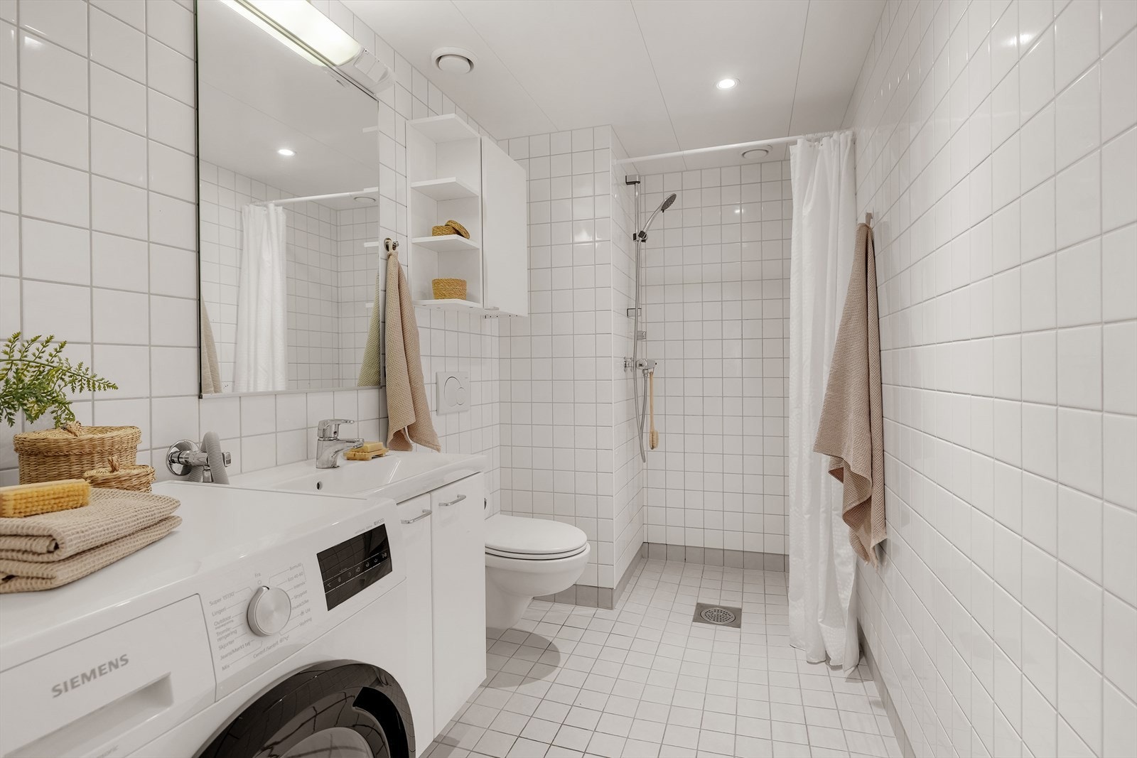 Lyst og delikat flislagt baderom med behagelige varmekabler i gulv. Galleribilde