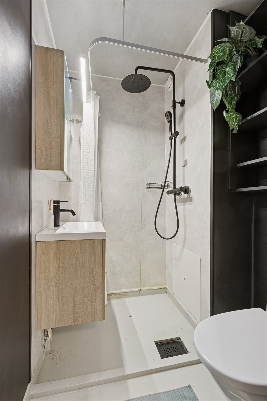 Den åpne dusjløsningen gir en romslig følelse og gjør det enkelt å bruke badet. Galleribilde