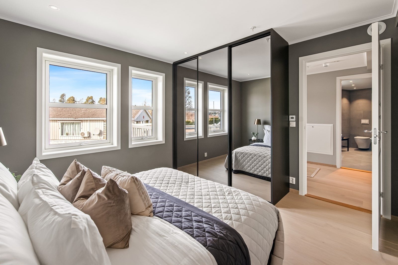 På begge soverommene er det mye oppbevaring i en plassbygget skyvedørsgarderobe med innredning og speilfronter i sort innramming. Galleribilde