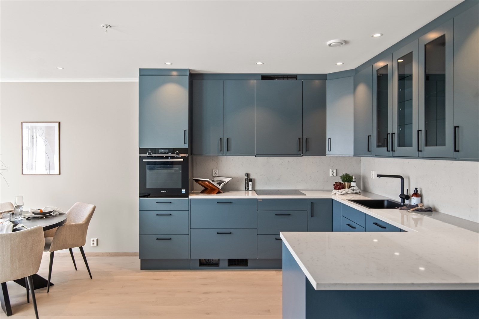 Kjøkkenet er stilrent og moderne, oppført i en smart u-form med god skap- og benkeplass. Galleribilde