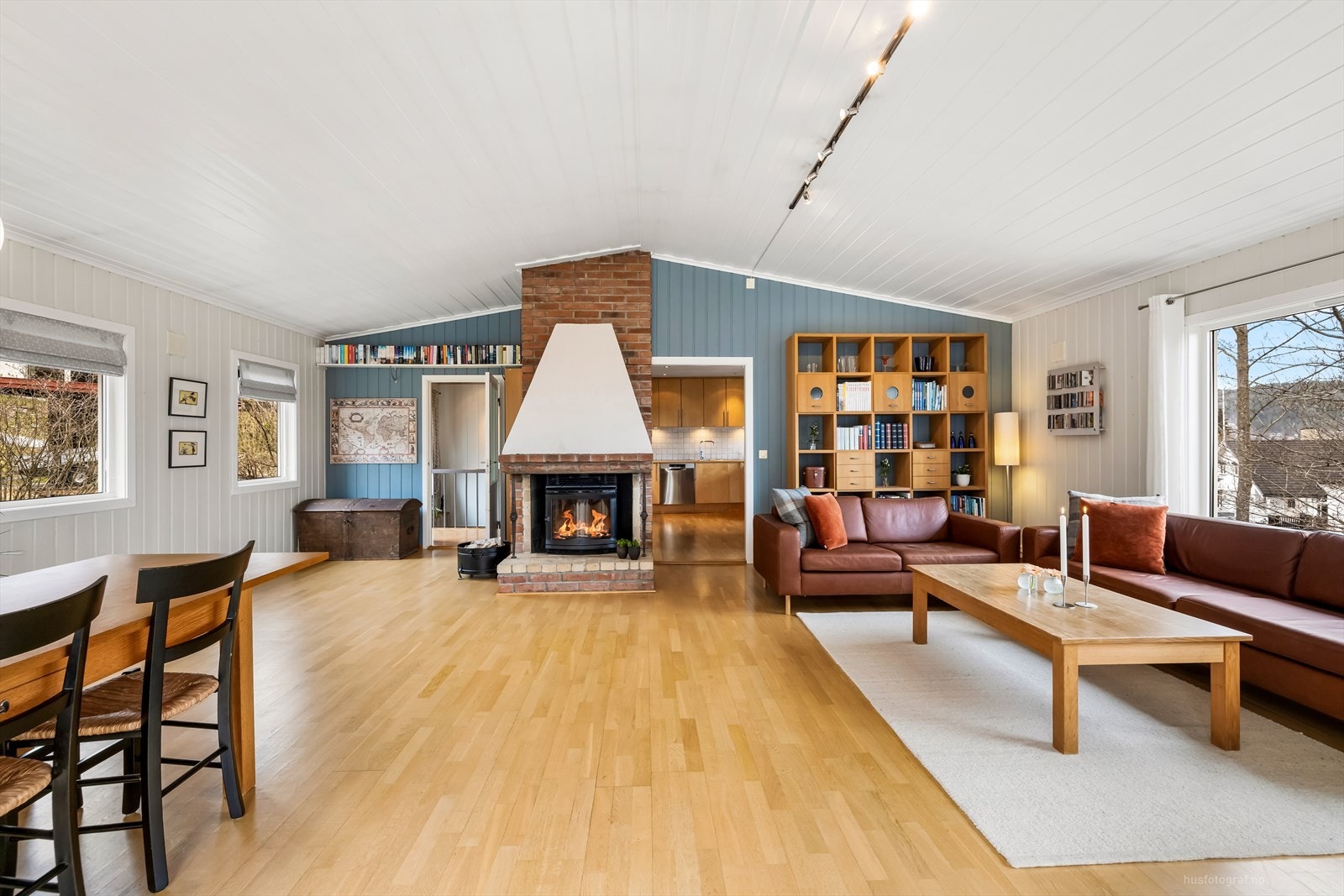 Peisen i mur er sentralt plassert i stuen og tilfører en lun og koselig stemning, perfekt for kalde vinterkvelder. Galleribilde