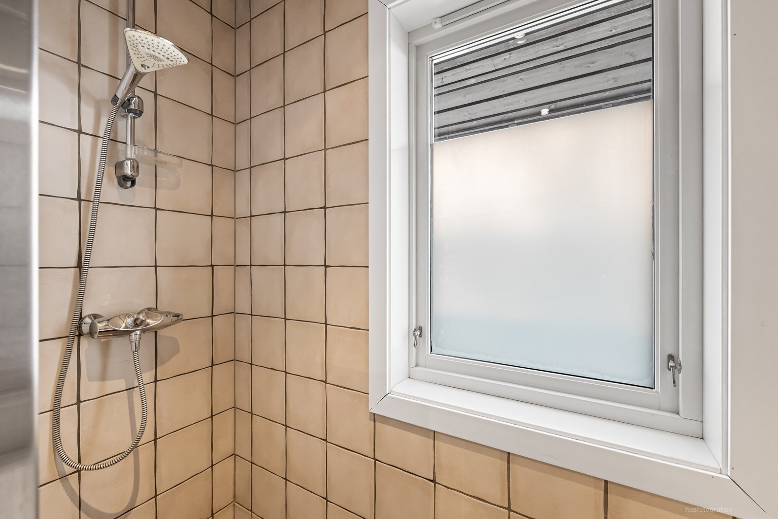 Videre er badet utstyrt med badekar, dusjarmatur og vegghengt toalett. Galleribilde