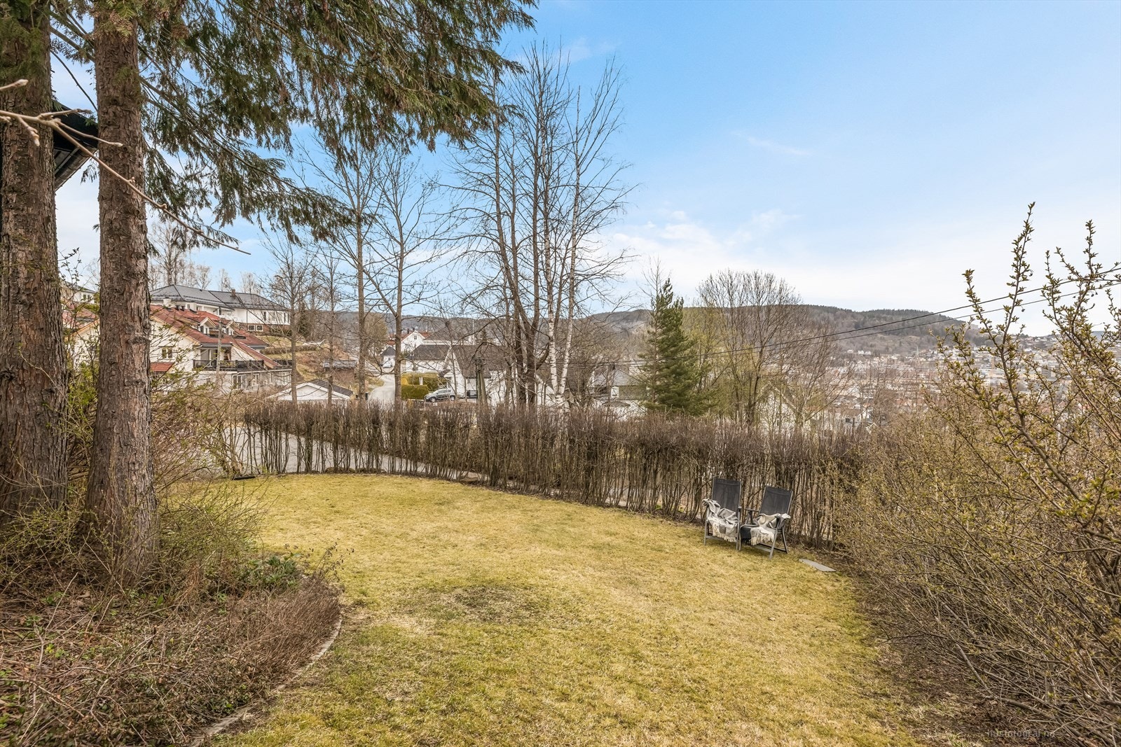 Grøntarealer med gressplen der barn og unge kan leke fritt som er delvis skjermet med hekk. Galleribilde