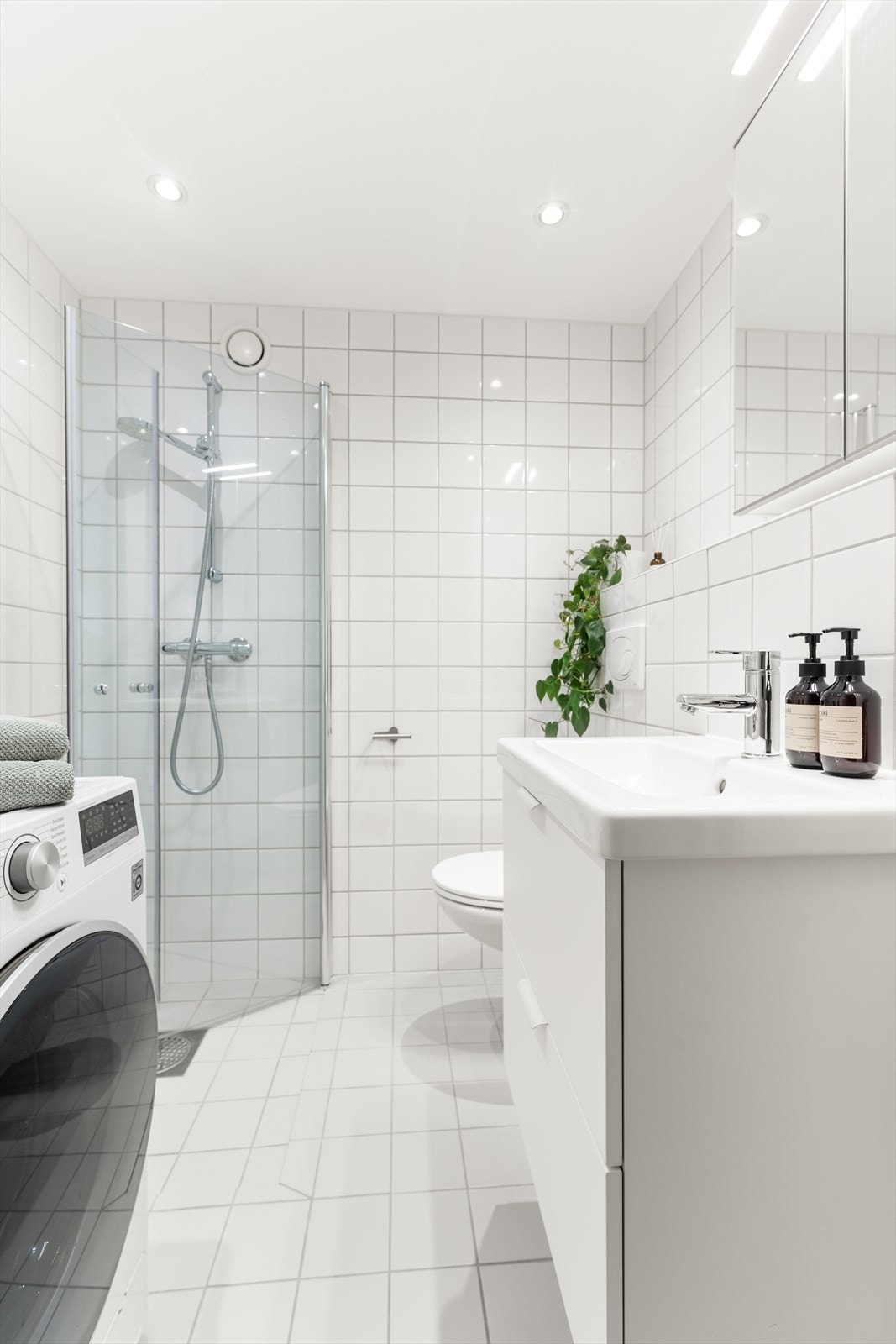 Rommet er innredet med servantskap med underskuffer, nedfelt servant og 1-greps blandebatteri. I tillegg har badet dusjhjørne med glassdører, vegghengt toalett og opplegg for vaskemaskin. Galleribilde