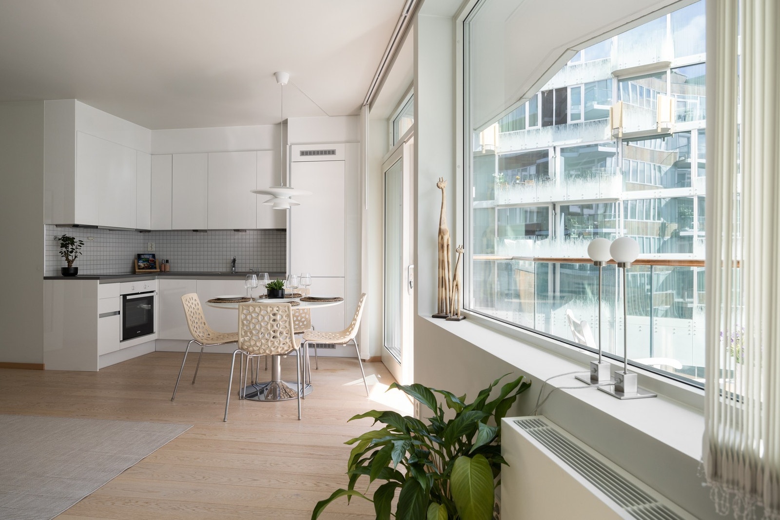 Kjøkken med tidløs, lys innredning og integrerte hvitevarer gir et sømløst og moderne uttrykk. Galleribilde