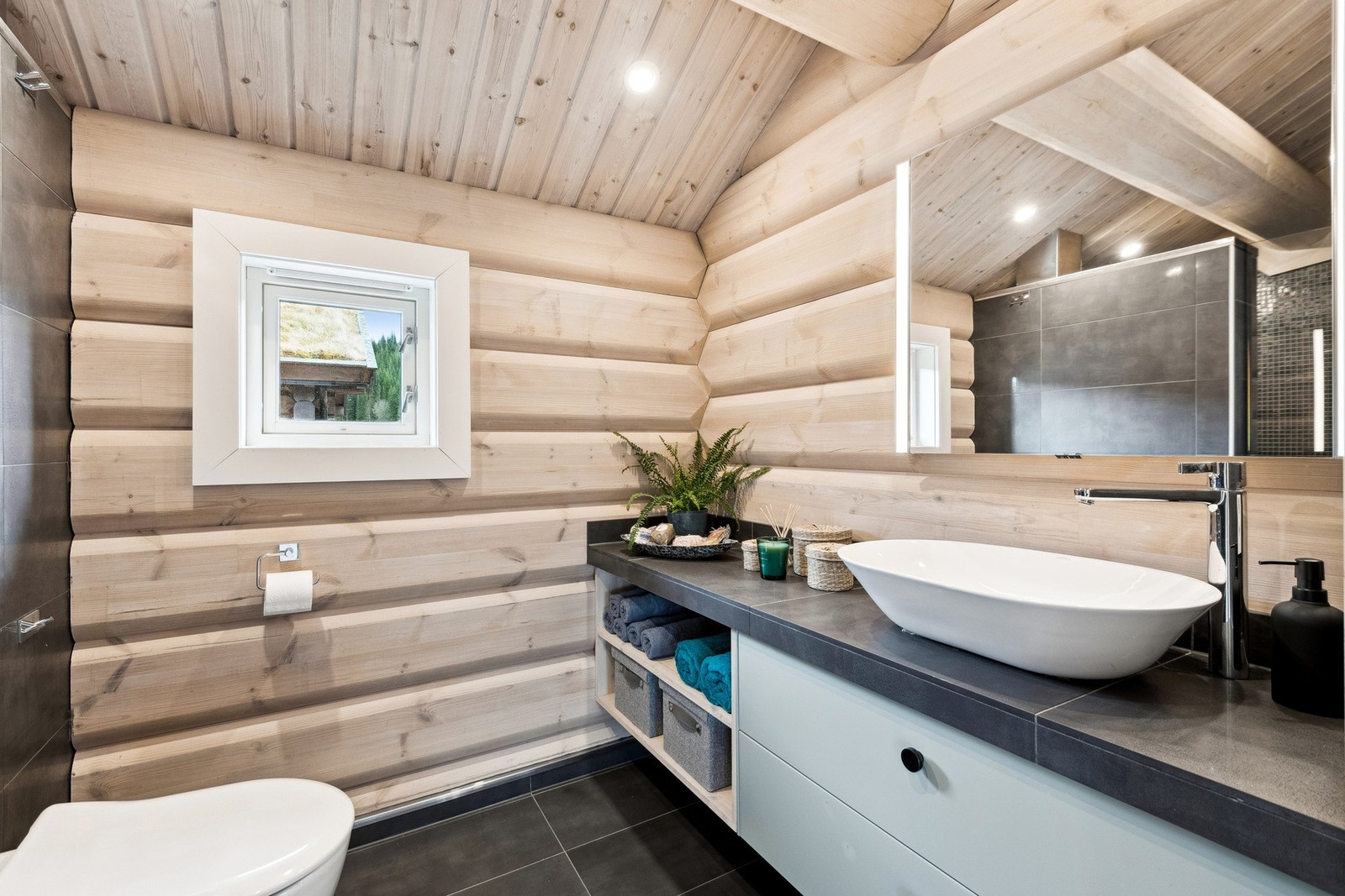 Badet har vegghengt toalett og dusjhjørne. Galleribilde