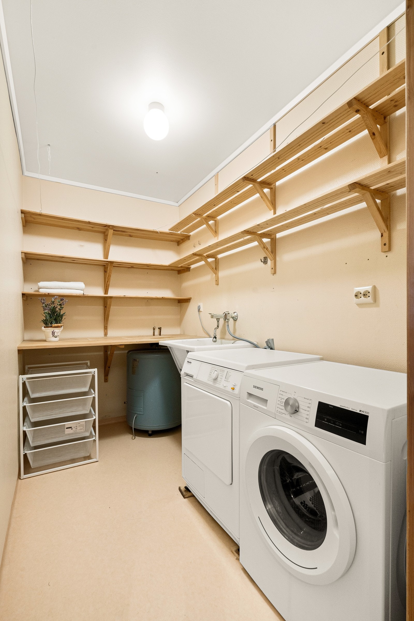 Praktisk vaskerom med god benkeplass og hyller Galleribilde