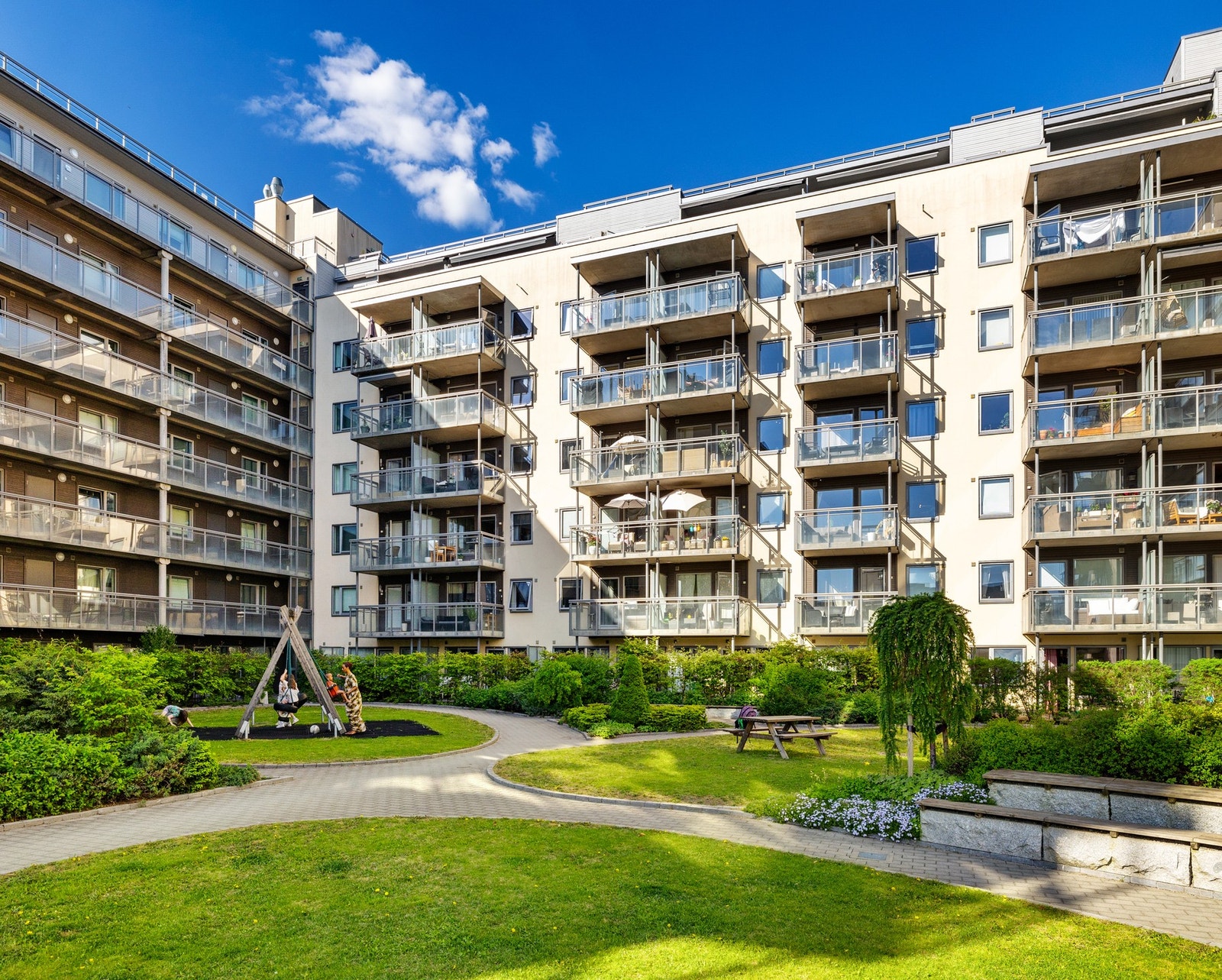 Flott gårdsrom med sittegrupper, beplantning og lekeplass Galleribilde