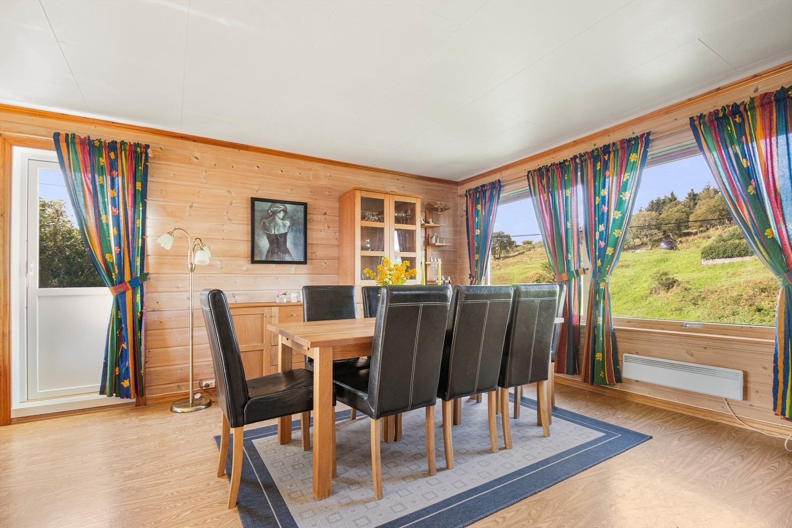 Store vindusflater slipper dagslyset inn i stuen. Her ser vi utgangen til terrassen. Galleribilde