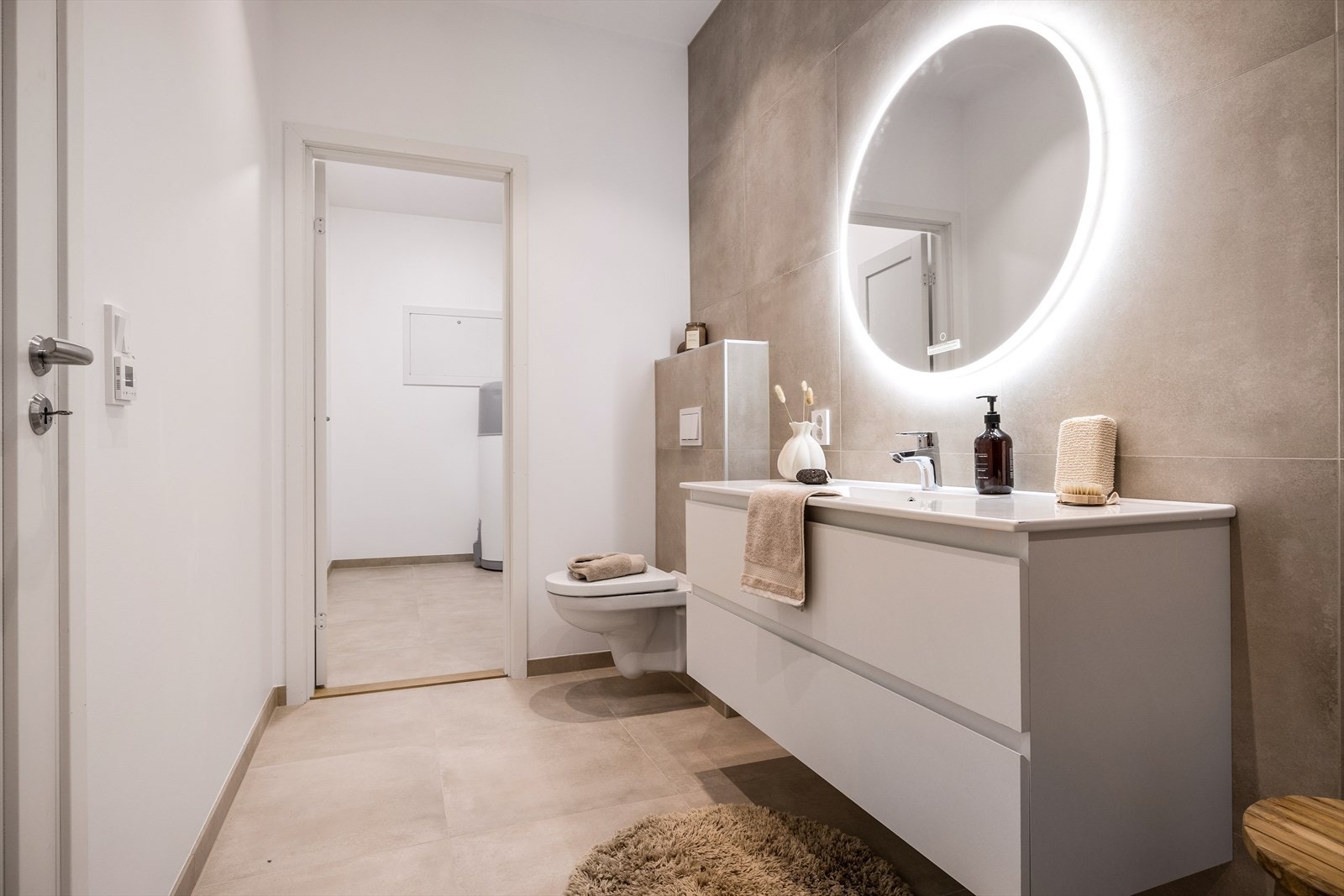 Badet er som i hovedetasjen, lekkert, og inneholder vegghengt toalett, helstøpt servant, skuffer under servant med slette fronter og dusjdører i klart glass. Galleribilde