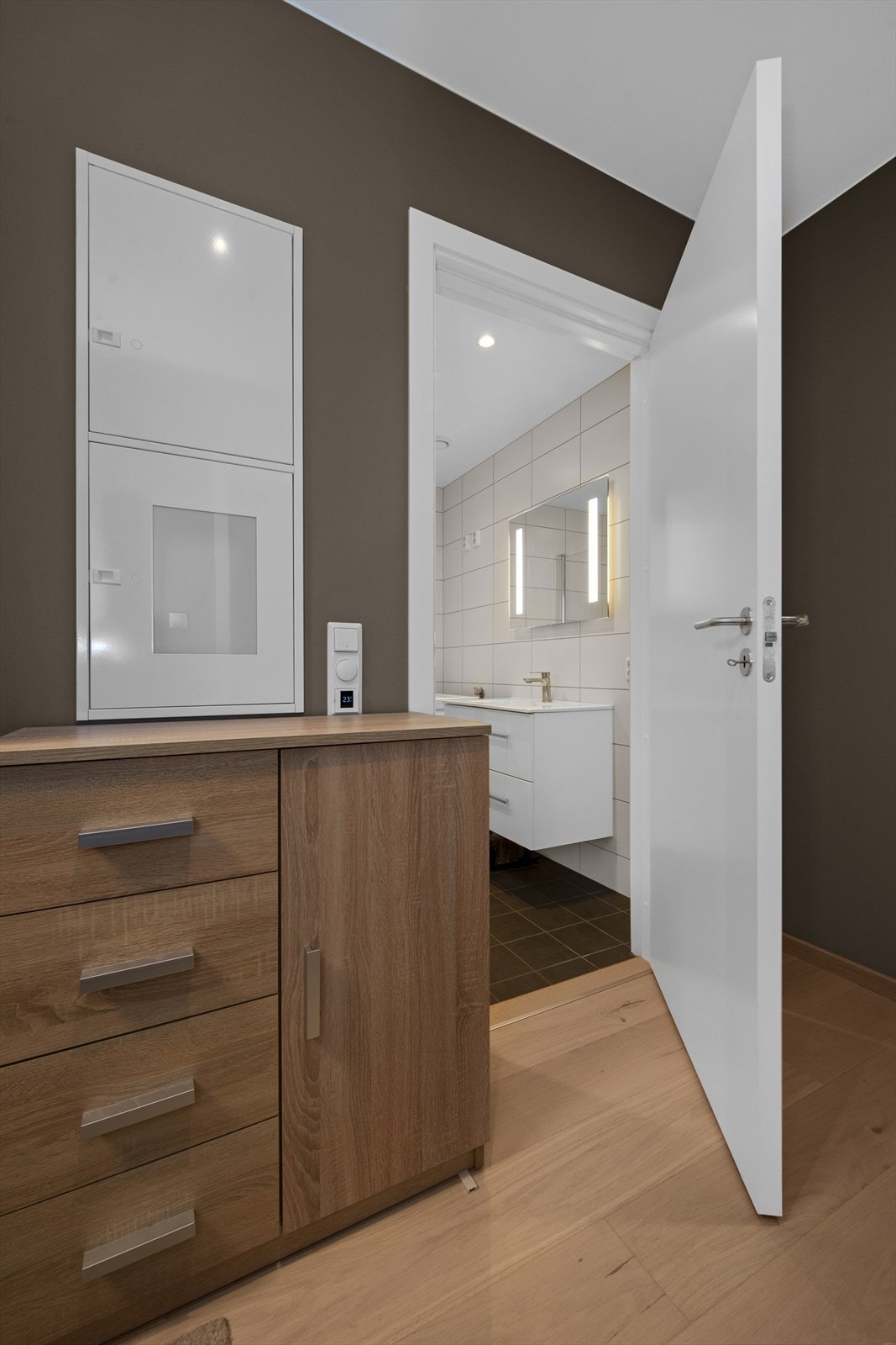 Gang med tilkomst til bad på en side og soverom med skyvedørsgarderobe på den andre siden Galleribilde