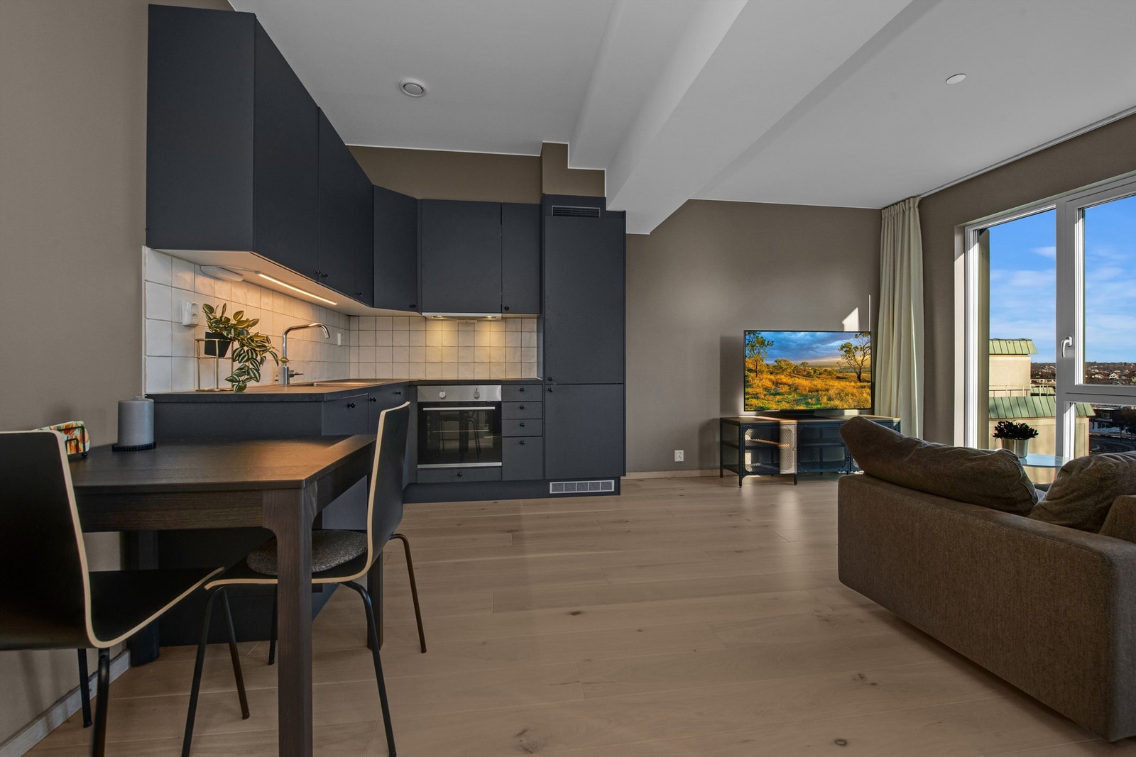 En pen kjøkkeninnredning fra Marbodal med integrert kombiskap, oppvaskmaskin, platetopp, stekeovn og ventilator Galleribilde