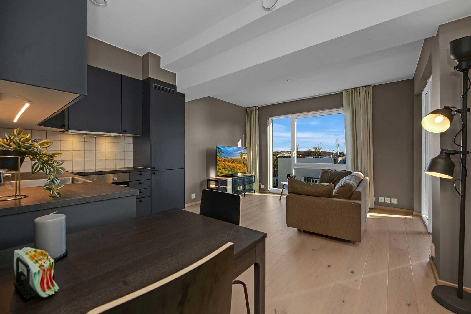 Åpen stue/kjøkkenløsning. Enstavs parkett på gulv. Galleribilde