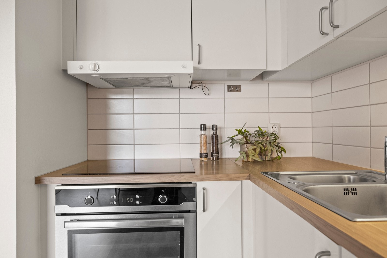 Du finner integrerte hvitevarer som platetopp, komfyr, oppvaskmaskin og kjøl/frys, noe som bidrar til en helhetlig og ryddig look Galleribilde