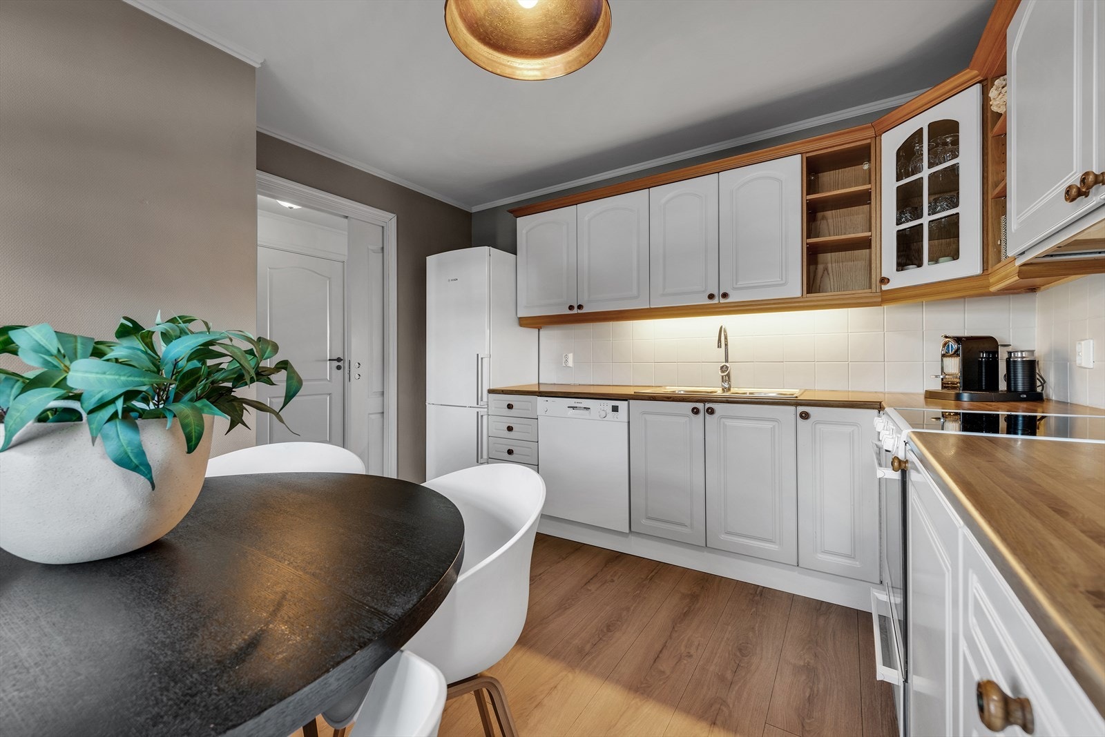 Lyst og velholdt kjøkken med stilrent design, perfekt for matlaging og sosiale sammenkomster. Optimal utnyttelse av plass. Galleribilde