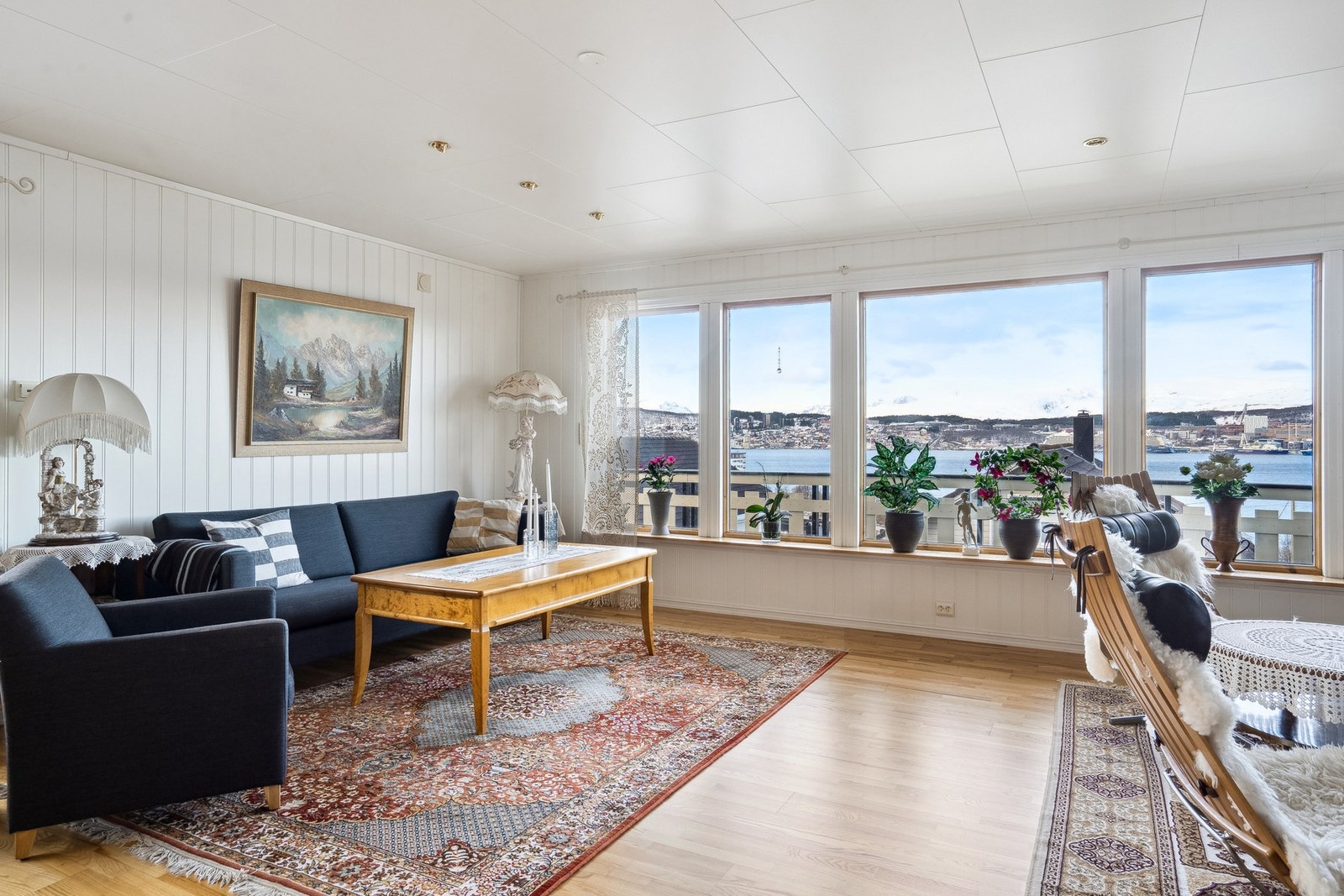 Stue med store vinduer i front med flott utsikt mot Tromsøysundet og Tromsøya. Galleribilde