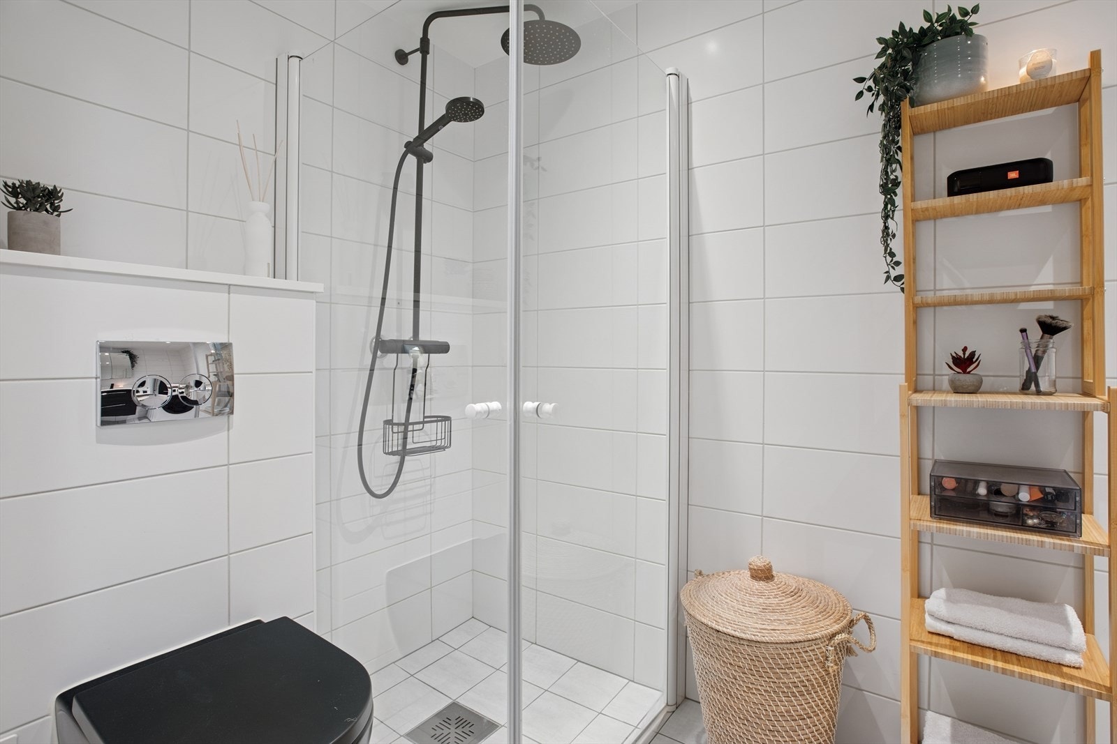 Dusjområdet har innfellbare glassdører med veggmontert dusjsett med både hånd- og regndusj. Videre inneholder badet veggmontert toalett og opplegg for vaskemaskin. Galleribilde