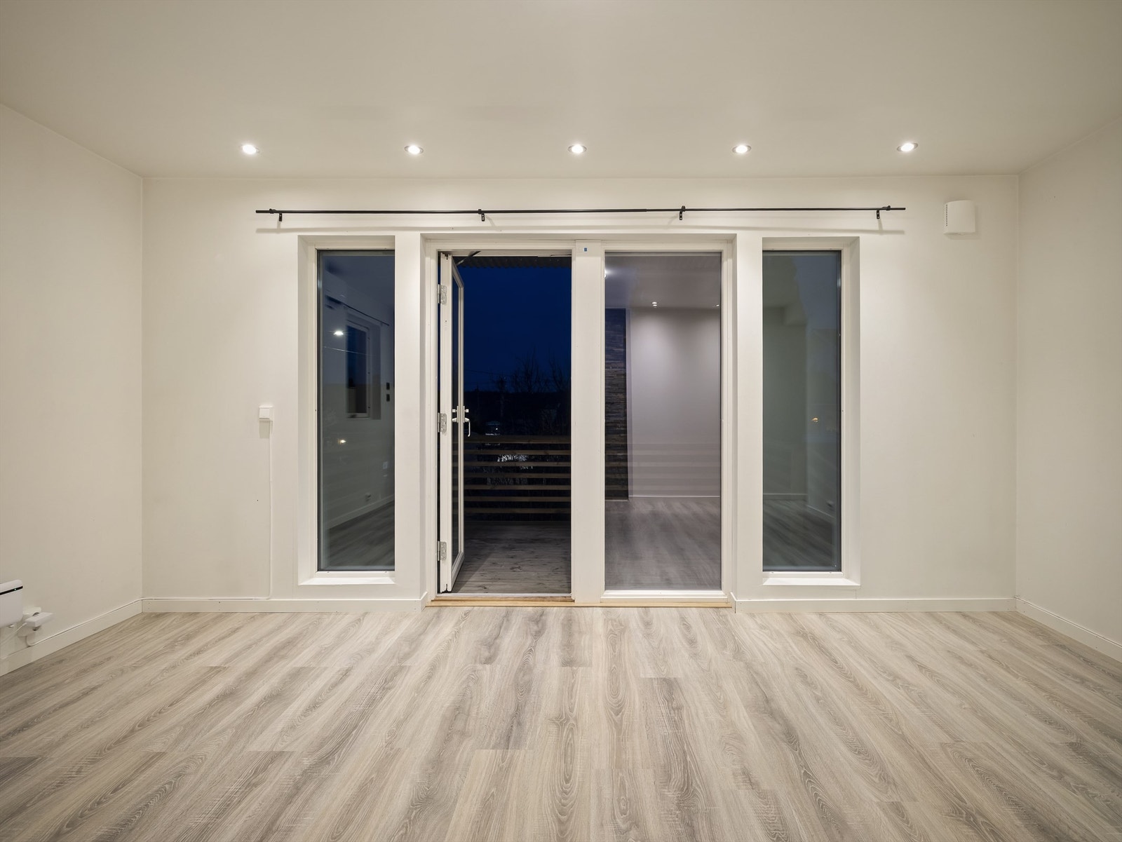 Vertikalstilte vinduer sørger for gode lysforhold i stuen på dagtid. Galleribilde