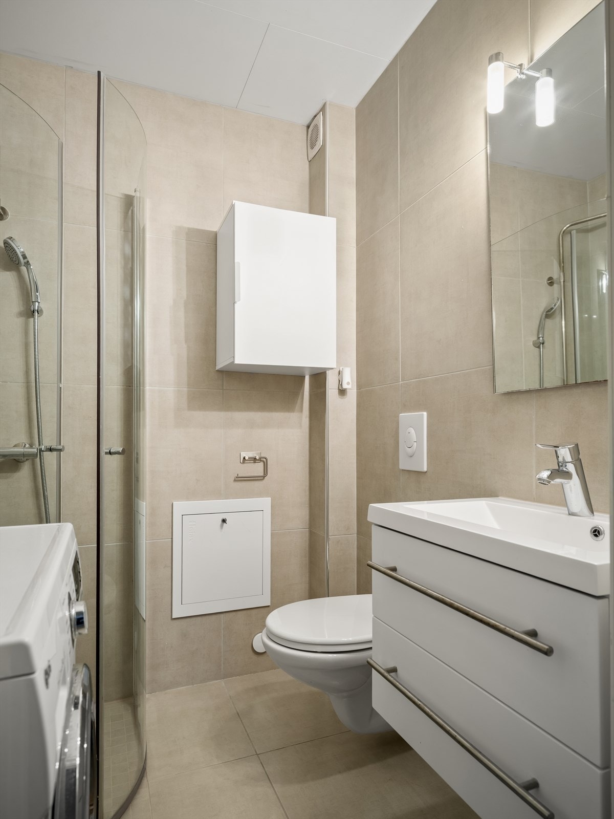 Badene er relativt likt utført. Gulv og vegger er med storformat fliser i varme, lyse nyanser som fremmer helhet. Galleribilde