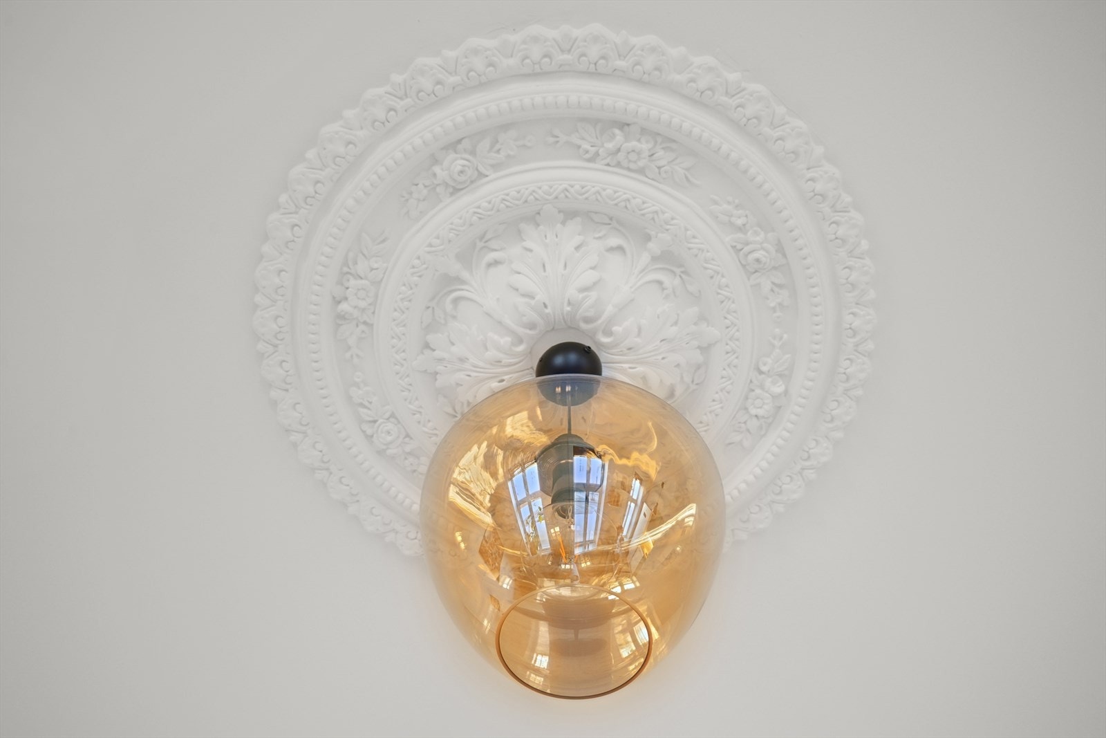 I stuen er det klassiske detaljer, som rosett med opphengsmulighet for lampe. Galleribilde