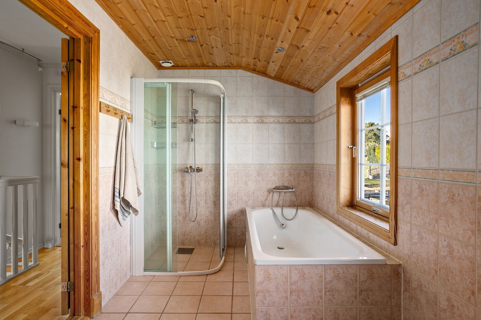 Romslig bad med både badekar og dusjhjørne, samt servant i innredning og toalett. Galleribilde