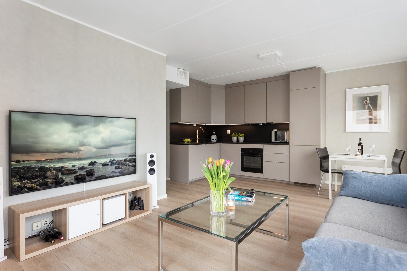 Stua og kjøkkenet ligger i en åpen sosial løsning. Rommet måler 27 kvm. Galleribilde