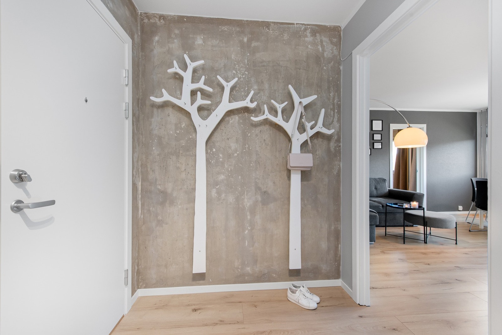 Leiligheten har en innbydende entré med plass til oppheng av yttertøy og sko. Veggene er malt i lyse, nøytrale farger, og gulvet er belagt med laminat som går igjen i store deler av boligen. Galleribilde