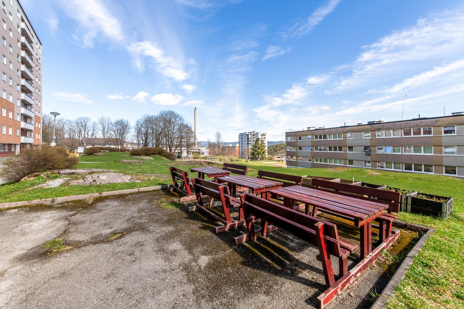 Felles tomt opparbeidet med asfalt, diverse beplantninger, plenareal, sittegrupper og biloppstillingsplass. Galleribilde