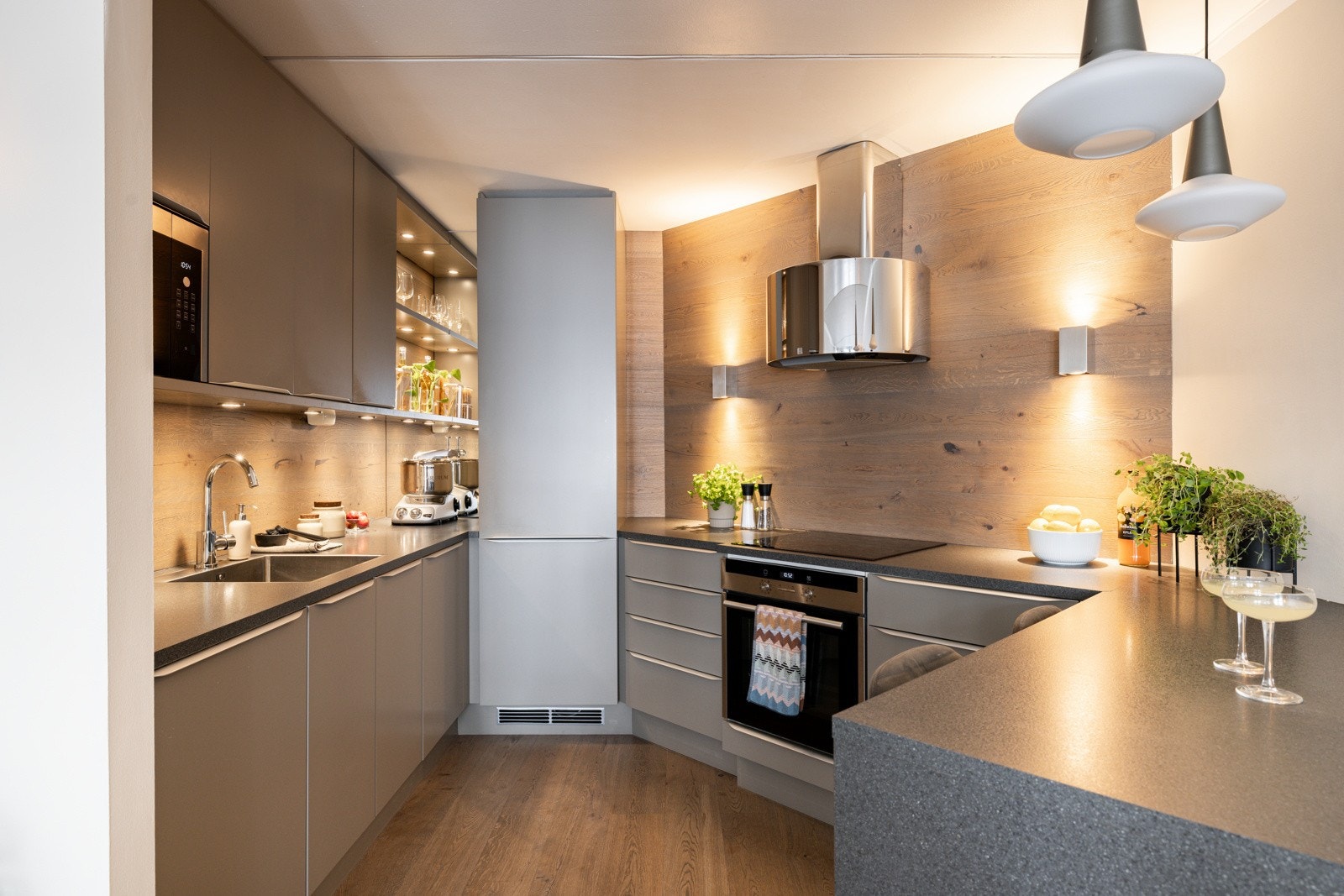 Medfølgende hvitevarer som nedfelt induksjonstopp, vegghengt ventilator med mekanisk avtrekk, stekeovn, mikrobølgeovn, oppvaskmaskin og kjøleskap med frysedel. Det er også montert lekkasjestopper med fuktsensor i benkeskap under oppvaskkum. Galleribilde