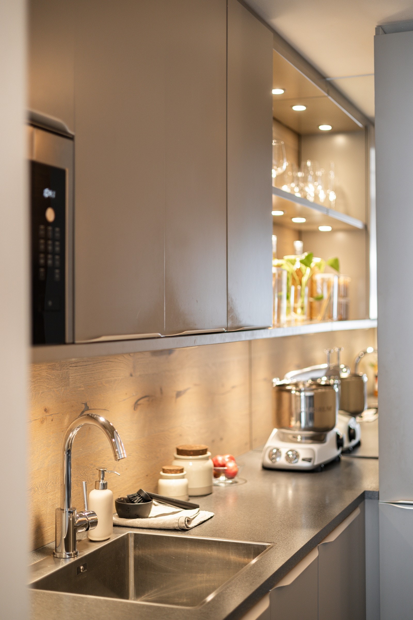 Flott detalj med speil på den innerste veggen og fine åpne hyller med integrert belysning. Enstavs mørk parkett er lagt i benkeryggen som gir et varmt uttrykk. Galleribilde