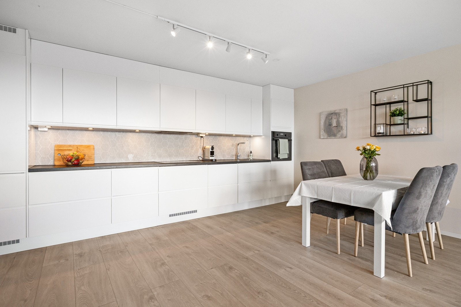 Moderne Epoq kjøkkeninnredning fra 2020, med stilrene glatte fronter, laminat benkeplate med nedfelt kum i rustfritt stål og integrerte hvitevarer fra Electrolux. Galleribilde