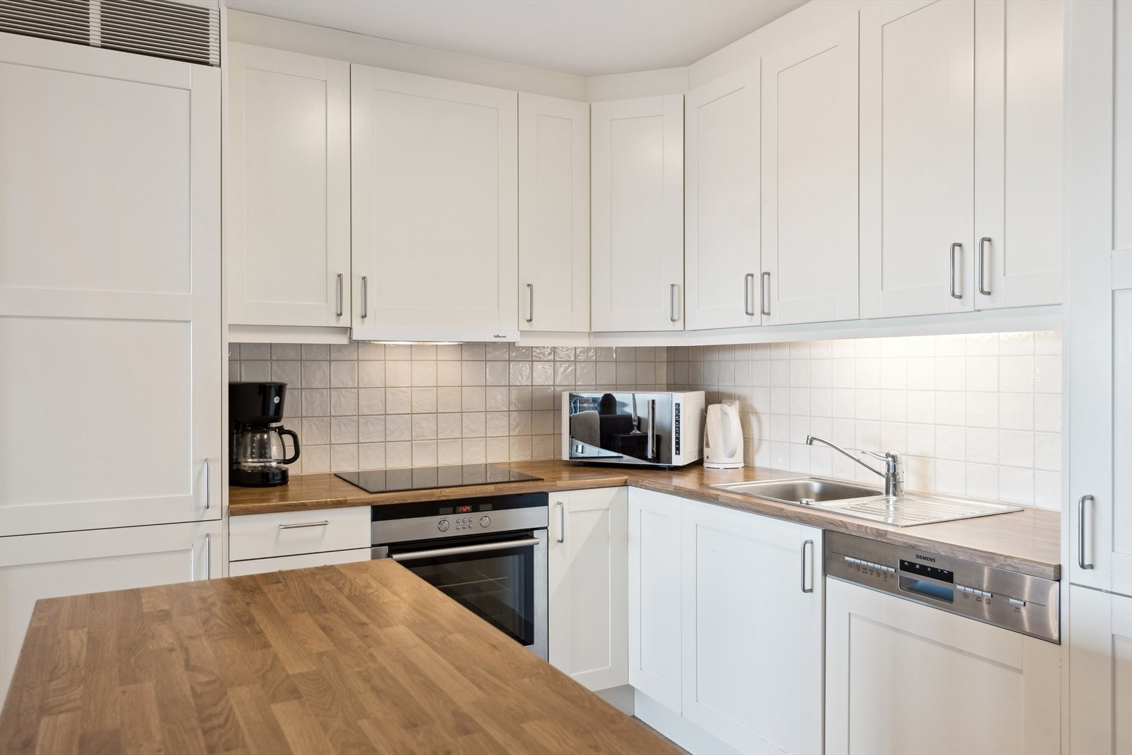 Kjøkkenet er funksjonelt og moderne, med innredning i malte, folierte plater, og rikelig med både over- og underskap. Galleribilde