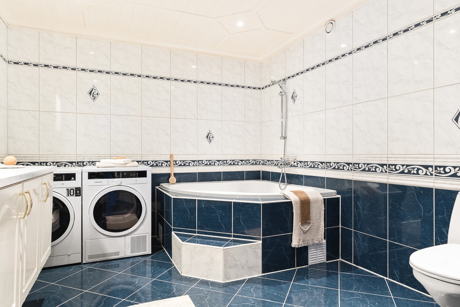 Videre har leiligheten et helfliset bad med varmekabler i gulvet. Galleribilde