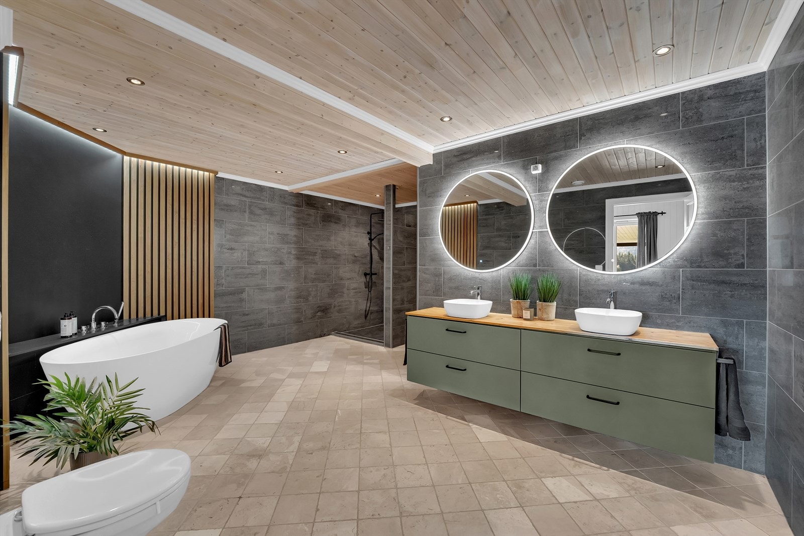 Stort, innbydende bad med "spa-følelse". Stor, dobbel servant med innredning, dusj, badekar og vegghengt toalett. Galleribilde