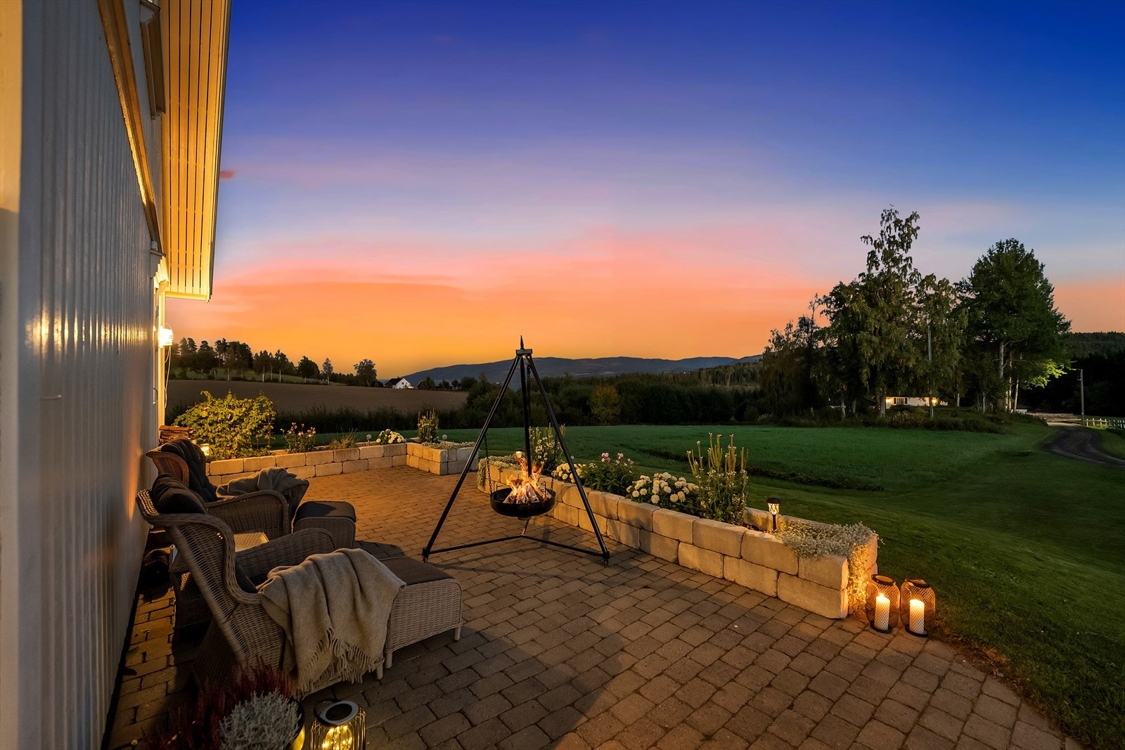 Pent opparbeidet uteplass med brostein, steinbedd og belysning. Galleribilde