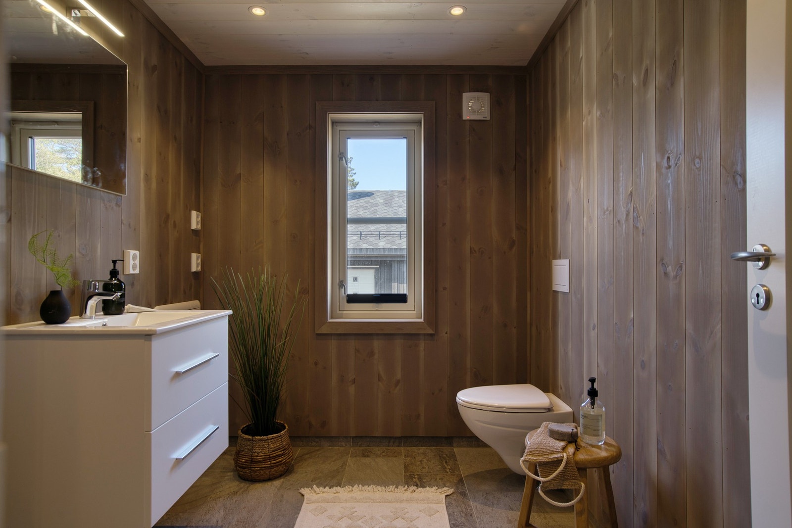 Moderne bad med baderomsinnredning, speil, veggmontert wc og dusjhjørne Galleribilde