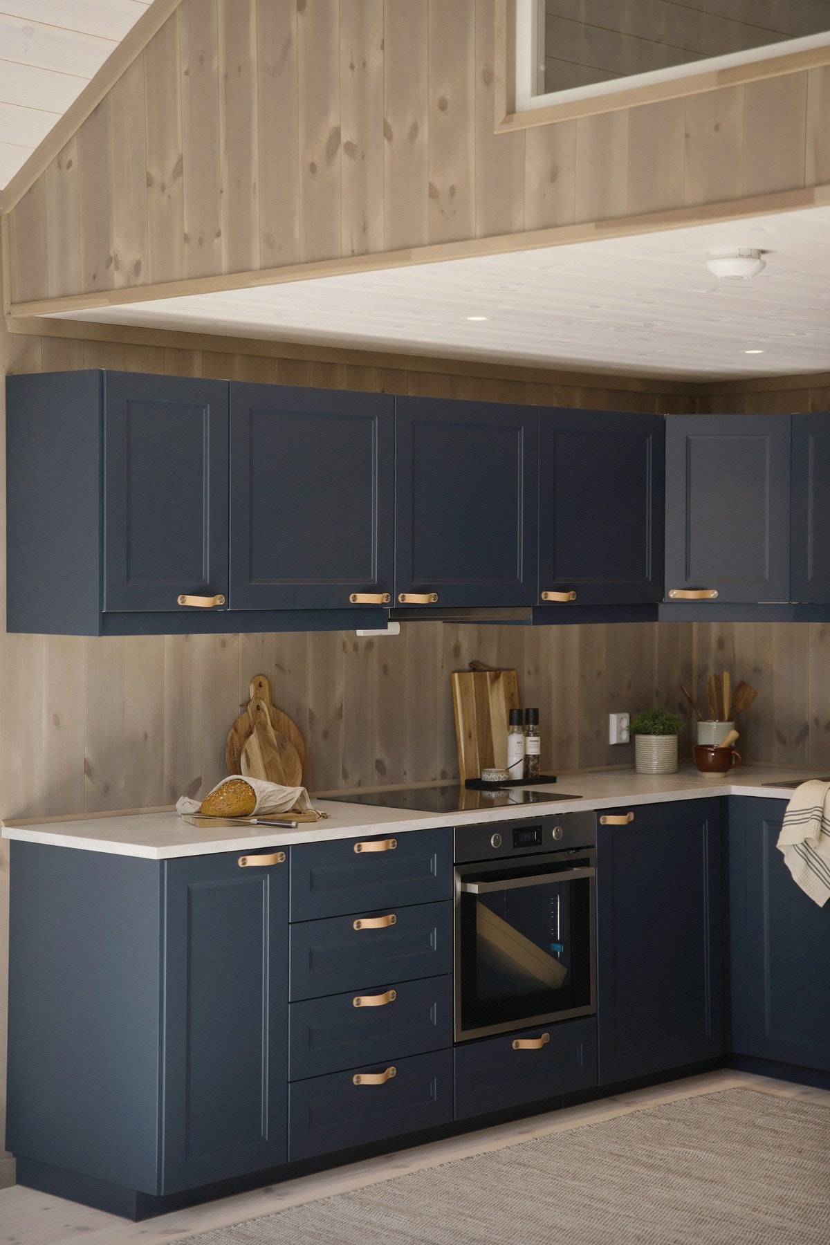 Stilrent og lekkert kjøkken med mørke profilerte fronter og en lys benkeplate Galleribilde