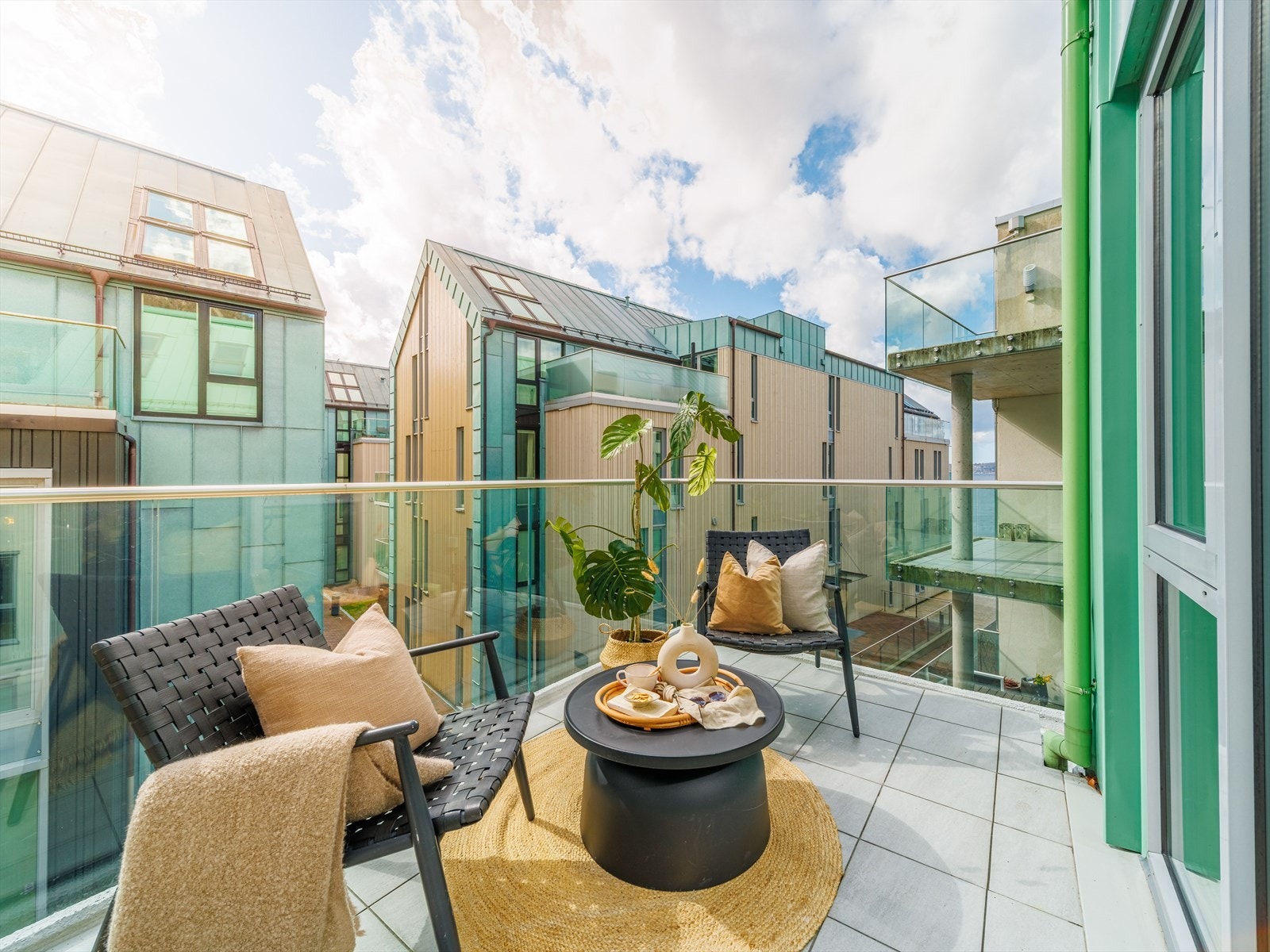 Moderne og elegant rekkverk i glass og aluminium, flislagt gulv, utelampe og strømuttak. Galleribilde