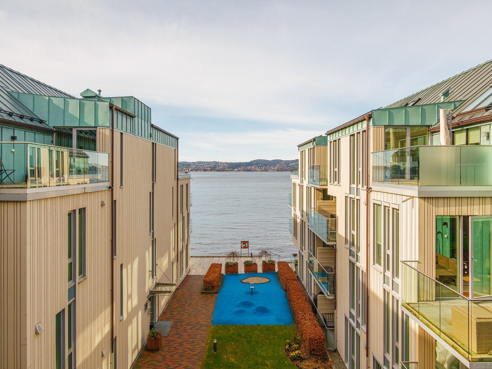 Sameiets uteområder er fint opparbeidet med brygge og veier med belegningsstein og asfalt Galleribilde