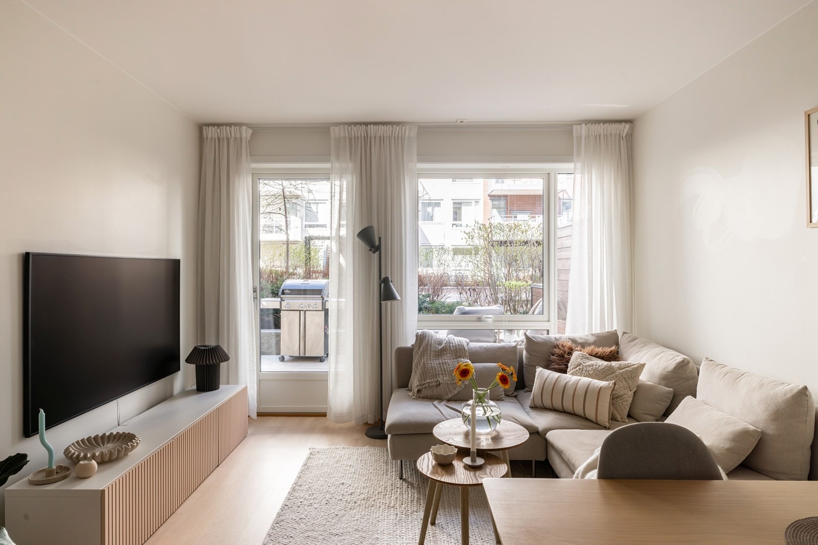 Lys og trivelig stue med lyse vegger og tidløs tre-stavs parkett på gulv. Galleribilde