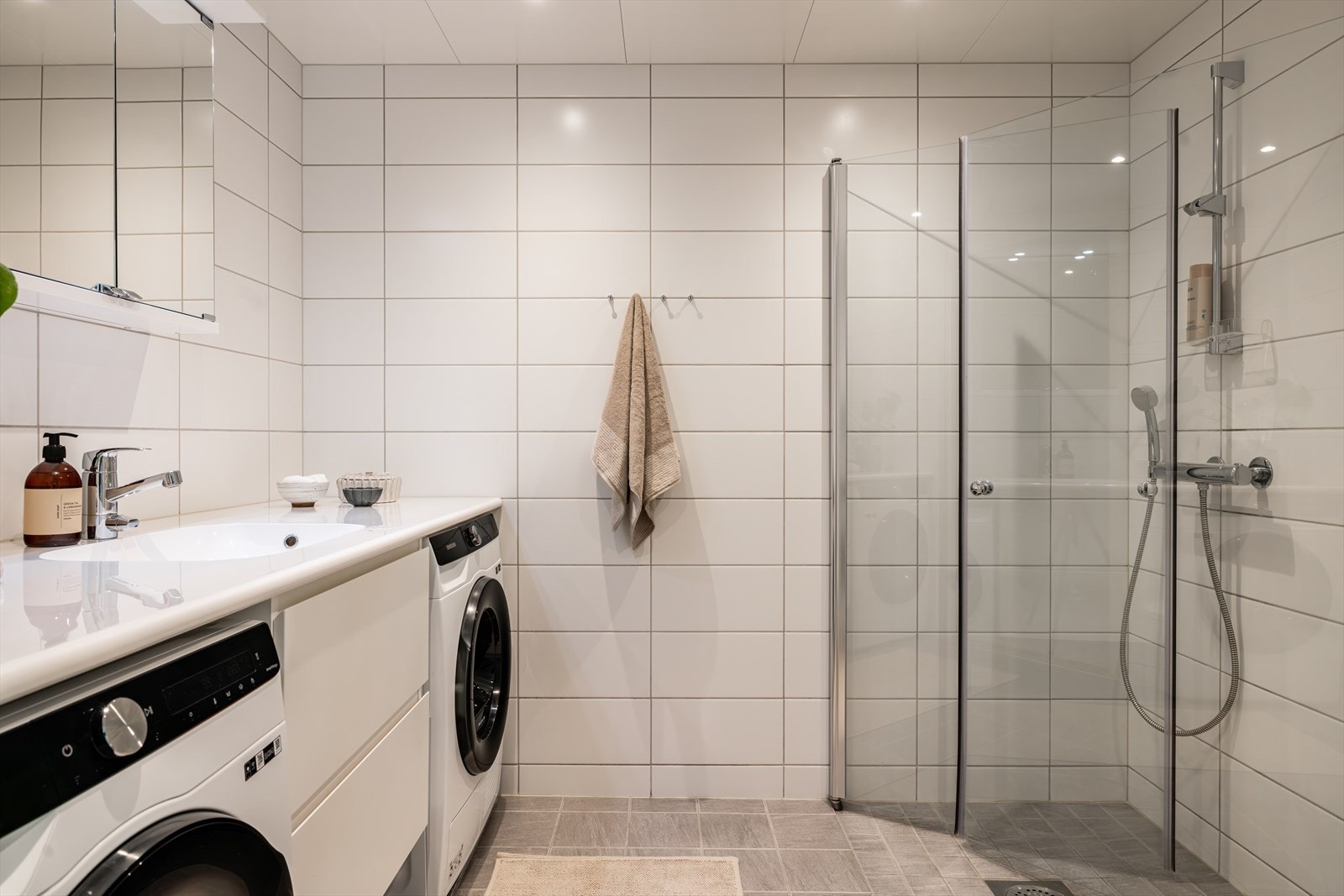 Rommet har nedsenket dusjnisje med innfellbare glassdører, vegghengt toalett og servant med ettgreps blandebatteri. Galleribilde